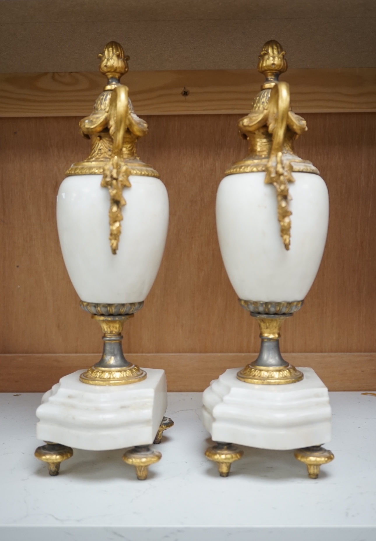 A pair of early 20th century white marble and gilt metal garnitures, 32cm. Condition - worn